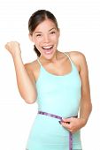 stock photo of fitness  - Weight loss concept woman smiling happy excited holding measuring tape around waist - JPG 