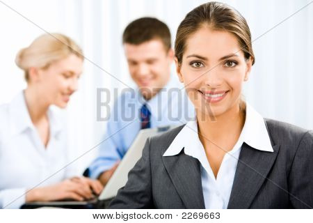 Picture or Photo of Young beautiful woman is holding a document on the background of business people