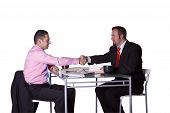 stock photo of business people  - Two Businessmen Shaking Hands at the Desk in an Office - JPG 