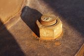 pic of industrial  - Dying industry and old industries as a business concept with an antique industrial rusted nut and bolt with the sun lighting setting on a market segment that is losing profitability and the needs modernisation.
** Note: Shallow depth of field - JPG 