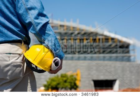 Picture or Photo of A construction worker or foreman at a construction site observing the progress of construction job or project with copy space