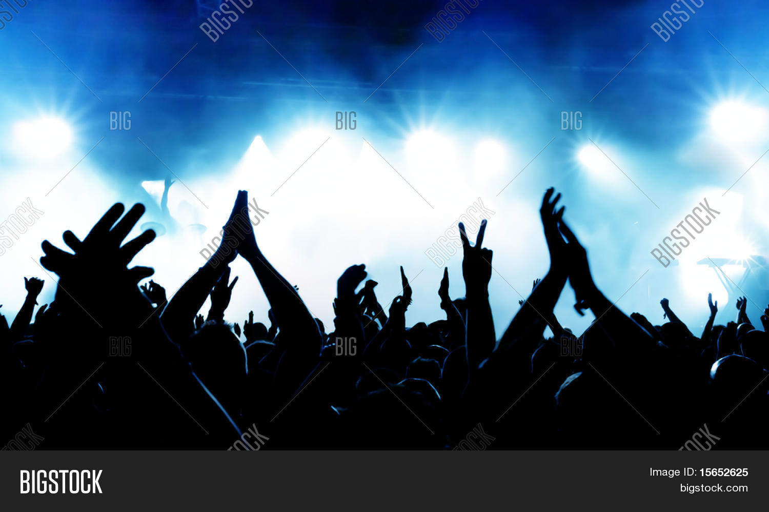 silhouettes of concert crowd in front of bright stage lights Stock