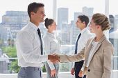 image of handshake  - Partners giving a handshake in a bright office - JPG 