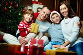 image of holidays  - Portrait of friendly family looking at camera on Christmas evening - JPG 