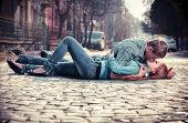 image of teenager  - Couple of teenagers lying in street together - JPG 