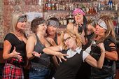 picture of tough  - Nerd flexes muscles for tough female gang in bar - JPG 