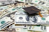 stock photo of money  - mini graduation cap on US money  - JPG 