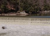 A waterfall below the calm water of Slippery Rock creek in the spring time at McConnells Mill, Pennsylvania