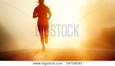 Picture or Photo of Runner athlete feet running on road. woman fitness silhouette sunrise jog workout wellness concept.