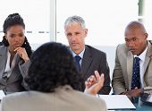 stock photo of meeting  - Business people attentively listening to a serious speaker in a meeting - JPG 