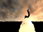 stock photo of health  - Concept or conceptual young man or businessman silhouette jump happy from cliff over  gap sunset or sunrise sky background as metaphor to freedom - JPG 