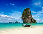 stock photo of beach  - Long tail boat on tropical beach with limestone rock - JPG 