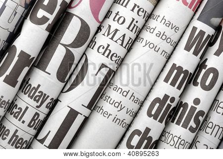 Picture or Photo of Newspaper headlines shown side on in a stack of daily newspapers