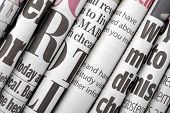 stock photo of newspaper  - Newspaper headlines shown side on in a stack of daily newspapers - JPG 