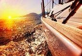 stock photo of sunset  - Yacht Sailing against sunset - JPG 