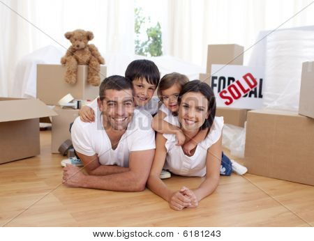 Picture or Photo of Happy family lying on floor after buying new house