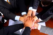 stock photo of business people  - group of business people making a pile of hands in a light and modern office environment - JPG 