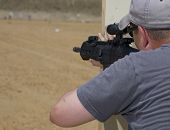 stock photo of steady  - Shooter at a target range steadying his rifle for a shot - JPG 