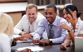 stock photo of meeting  - Happy business people sitting around the table at the meeting - JPG 