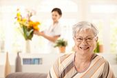 picture of home  - Portrait of happy elderly woman sitting on sofa at home - JPG 