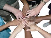 pic of diversity  - a diverse team of workers standing in a circle with their hands syacked to showcase teamwork and unity isolated on a white background via clipping path - JPG 