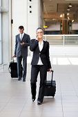 image of businesspeople  - businesspeople walking in airport with luggage - JPG 
