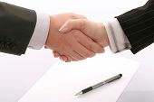 picture of handshake  - Business handshake over page with pen in white paper - JPG 