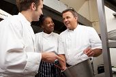 foto of restaurant  - Chef Instructing Trainees In Restaurant Kitchen - JPG 