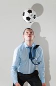 picture of business people  - caucasian business man is playing football at office near gray wall - JPG 