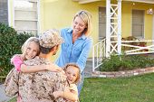 stock photo of home  - Family Welcoming Husband Home On Army Leave - JPG 