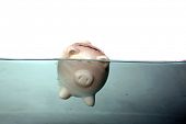 image of monetary  - a piggy bank floats in dark murkey water - JPG 