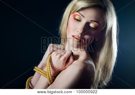 Beautiful girl with a rope and bright makeup