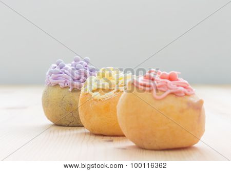3 Color Choux Or Profiterole Or Eclair On Wood Table Oblique View