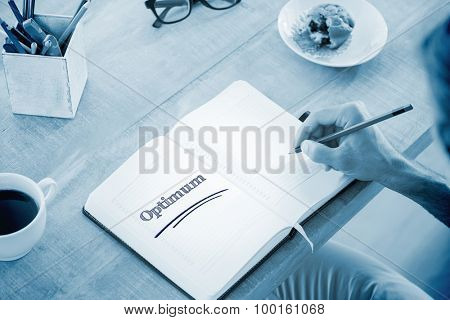 The word optimum against man writing notes on diary