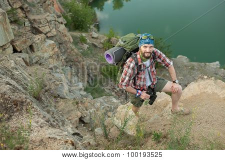 Young caucasian man with backpack climbing the rock