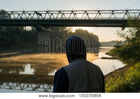 Man In A Hood At Border River Tisza Between Hungary And Ukraine