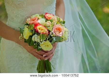 Beautiful wedding flowers in bride hands. Close up