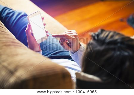Woman Touching Mobile Screen With Finger, Laying At Home. White Screen.