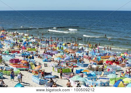 REWAL - AUGUST 13: Tourists enjoy the sunny weather and relaxing on the Baltic sea beach on 13 August 2015 in Rewal, Poland.