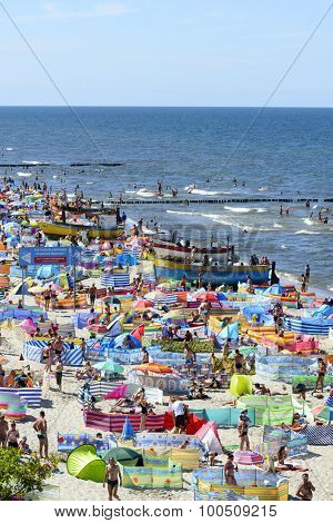 REWAL - AUGUST 13: Tourists enjoy the sunny weather and relaxing on the Baltic sea beach on 13 August 2015 in Rewal, Poland.
