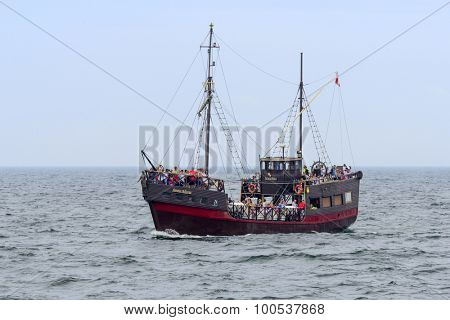 KOLOBRZEG - AUGUST 12: Tourists enjoying the sunny weather and a cruise ship 