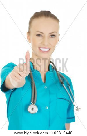 Beautiful smiling woman doctor with thumbs up.