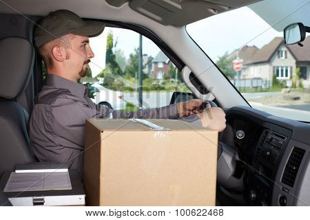 Young delivery man in the car. Parcel service.