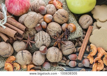 Apples, pears, walnuts, pine nuts, hazelnuts, cinnamon and star anise on the table