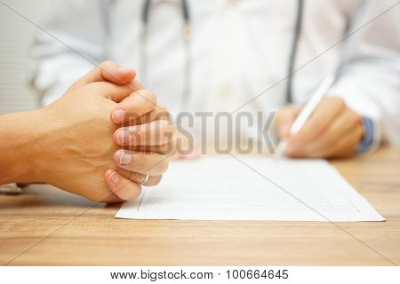 Hands Of Concerned Women For A Medical Report Written By A Doctor On The Medical Condition
