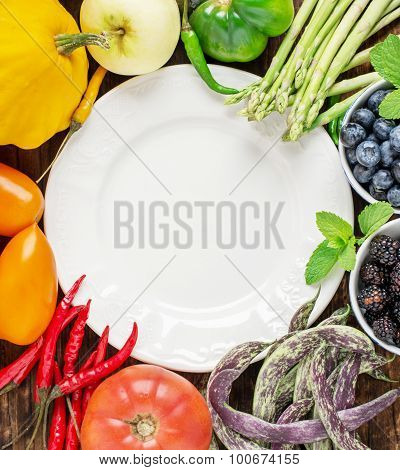 Fruits and vegetables of all colors the rainbow on a wooden table over white plate