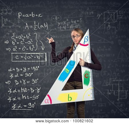 female student with a big ruler pointing at  Pythagorean theorem on blackboard