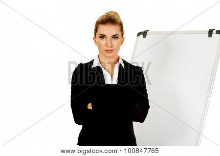 Young business woman standing nex to the white board.