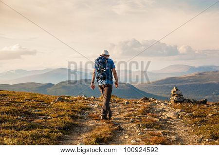 hiker with backpack traveling in Norway mountains Dovre