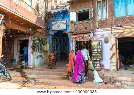 JODHPUR RAJASTHAN INDIA - MARCH 04 2016: Wide angle picture of three women dressing swari indian traditional clothes in Jodhpur the blue city of Rajasthan in India.